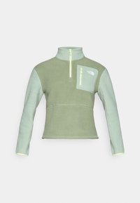 Fleece pullover in lichtgroen met een ritskraag, voorzien van een borstzak en contrasterende details op de mouwen en zoom in een vergelijkbare tint.