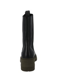 Botas de cuero negro hasta el tobillo con un acabado suave, que cuentan con una solapa, paneles laterales elásticos y una suela blanca gruesa.