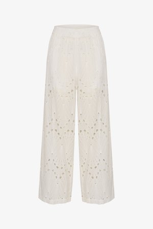Pantalons larges blancs brodés avec des motifs découpés, dotés d'une ceinture élastique confortable et d'un tissu doux et texturé.