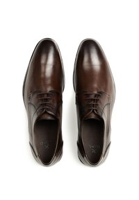 Brune lædersko til dress med en glat finish, snørebånd, rundet tå og diskrete syninger langs siderne og toppen.