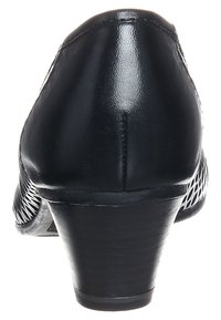 Svart läderklackskor med sluten baksida, texturerad sida och en måttlig blockklack. Slät yta med vävd mönster.