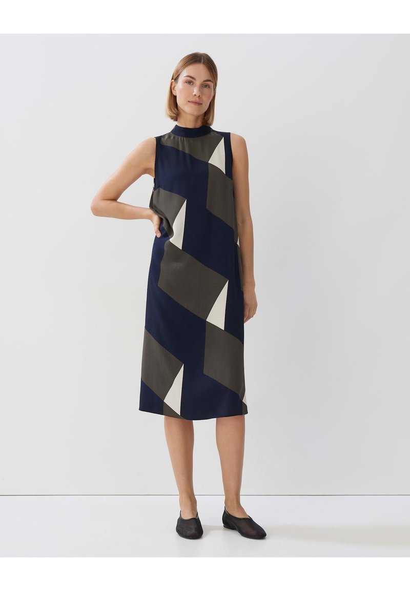 Dunkelblaues ärmelloses Kleid mit geometrischen beige- und olivgrünen Mustern. Gerader Schnitt, knielang mit hohem Ausschnitt. Glatte Stofftextur.