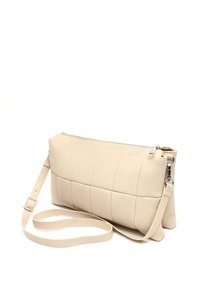 Beige neplederen handtas met een gecapitonneerd ontwerp, rechthoekige vorm, ritssluiting en verstelbare schouderband. Zachte textuur en minimalistische stijl.