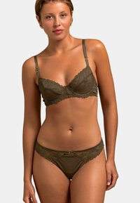 Ensemble de lingerie vert olive avec des accents en dentelle. Le soutien-gorge possède des armatures, des bretelles réglables et des détails floraux ; string assorti avec une bordure en dentelle similaire.