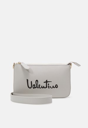 Hellgraue Valentino Handgelenktasche mit schwarzem Logoschriftzug, goldfarbenem Reißverschluss und passendem abnehmbarem Riemen vor schlichtem weißem Hintergrund.