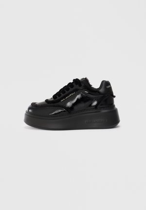 Sneaker in pelle patent nera con suola platform, dotata di dettagli in pelliccia sintetica, lacci rotondi e logo sul lato e sul tallone.
