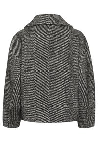 Jacka med houndstooth-mönster i svart och vitt, med slagkrage och en kort silhuett, i en texturerad tyg.