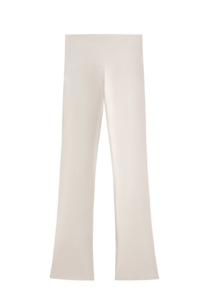 Urtunnade leggings i en ljus beige färg, tillverkade av ett mjukt, stretchigt tyg med en bred midjeresår; inga synliga mönster eller hårdvara.