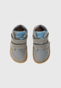 Grå børnesko med mesh- og ruskindsmaterialer, velcrolukninger, kontrastfulde blå accenter og gummisåler for fleksibilitet og greb.
