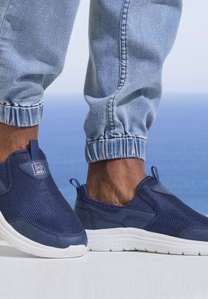 Navy blue slip-on shoes made of mesh and synthetic fabric, featuring a white rubber sole and logo detail on the side.