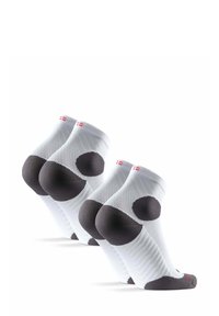 Calcetines deportivos blancos con tejido texturizado, refuerzo en el talón y la punta de color gris oscuro, y pequeño detalle del logotipo rojo en el puño. Se muestran tres pares.