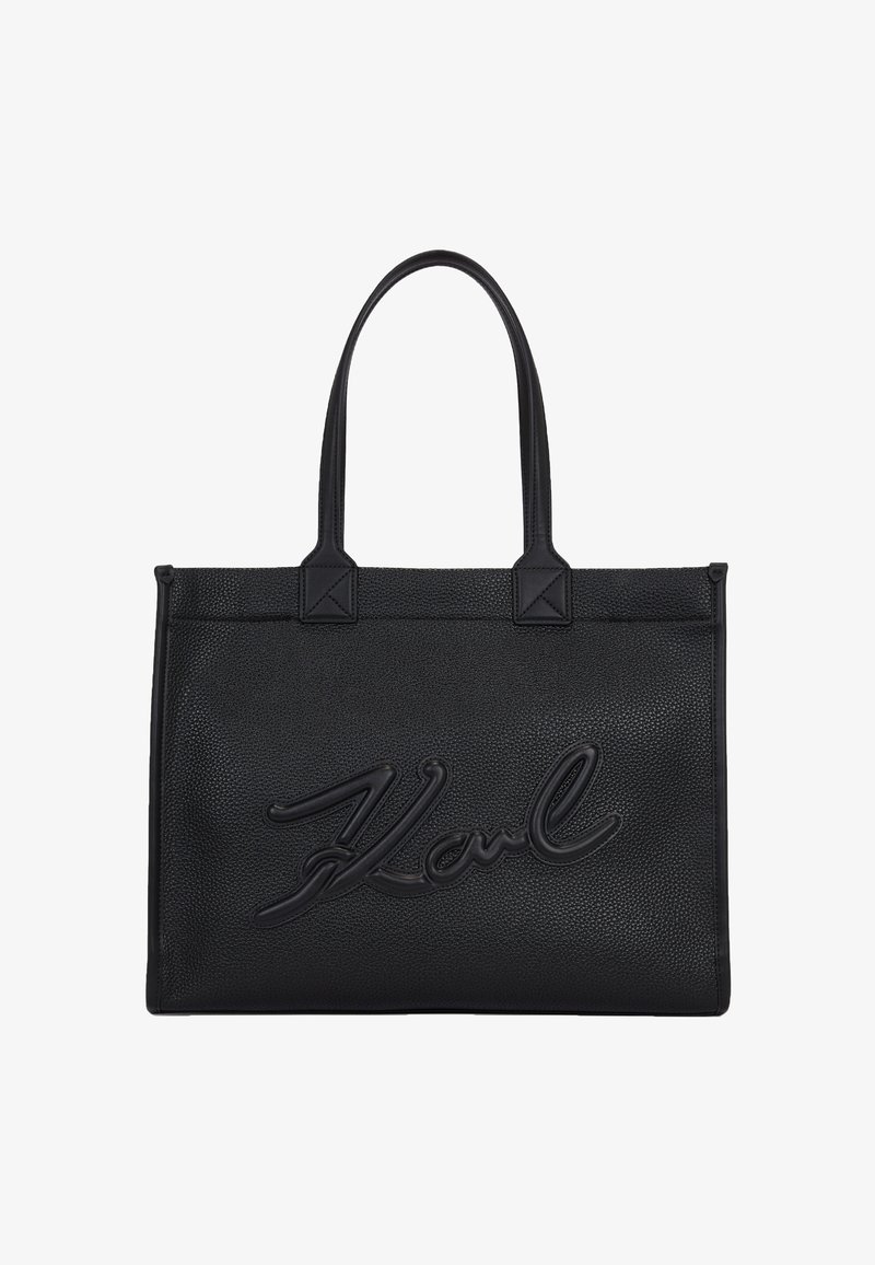 Mustan nahkainen olkalaukku, jossa on teksturoitu pinta ja kohokuvioitu "Karl"-logo. Kaksoiskahvat ja laatikkomainen muoto, jossa on kulmikkaita kulmia.