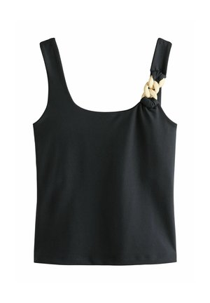 Giovane donna con capelli castani lunghi, indossa una canotta nera e pantaloni abbinati, guarda oltre la spalla, sfondo neutro.