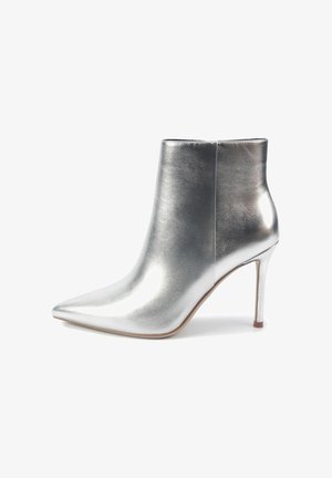 Metalni srebrni gležnjači s uskim nosom in stiletto peto. Gladka tekstura, minimalni šivi in elegantna zasnova poudarjajo sodobno estetiko.