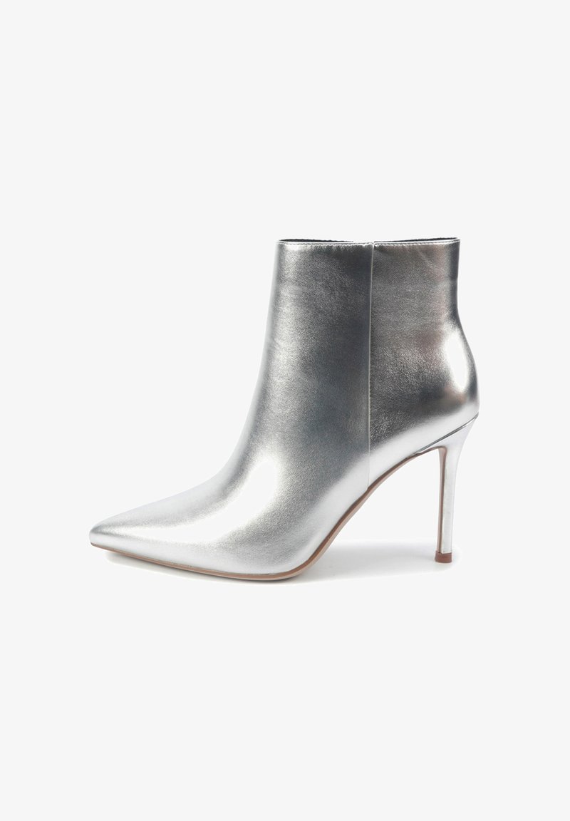 Botină metalică argintie cu vârf ascuțit și toc stiletto. Textură netedă, cusături minime și un design elegant pun accent pe estetica modernă.