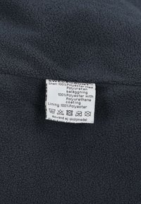 Donkergrijs fleece-stof met een zachte textuur. Het verzorgingslabel vermeldt dat de samenstelling van het materiaal is: buitenlaag en voering zijn 100% polyester.