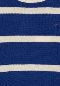 Maglione a righe in lavorazione a maglia con corpo blu e strisce orizzontali bianche. Include un tessuto testurizzato e un logo ricamato nell'angolo.