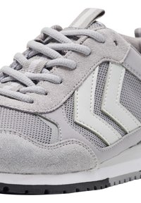 Szare sneakersy z cholewką wykonaną z połączenia zamszu i siateczki, białymi paskami akcentującymi, okrągłymi sznurowadłami oraz teksturowaną gumową podeszwą.