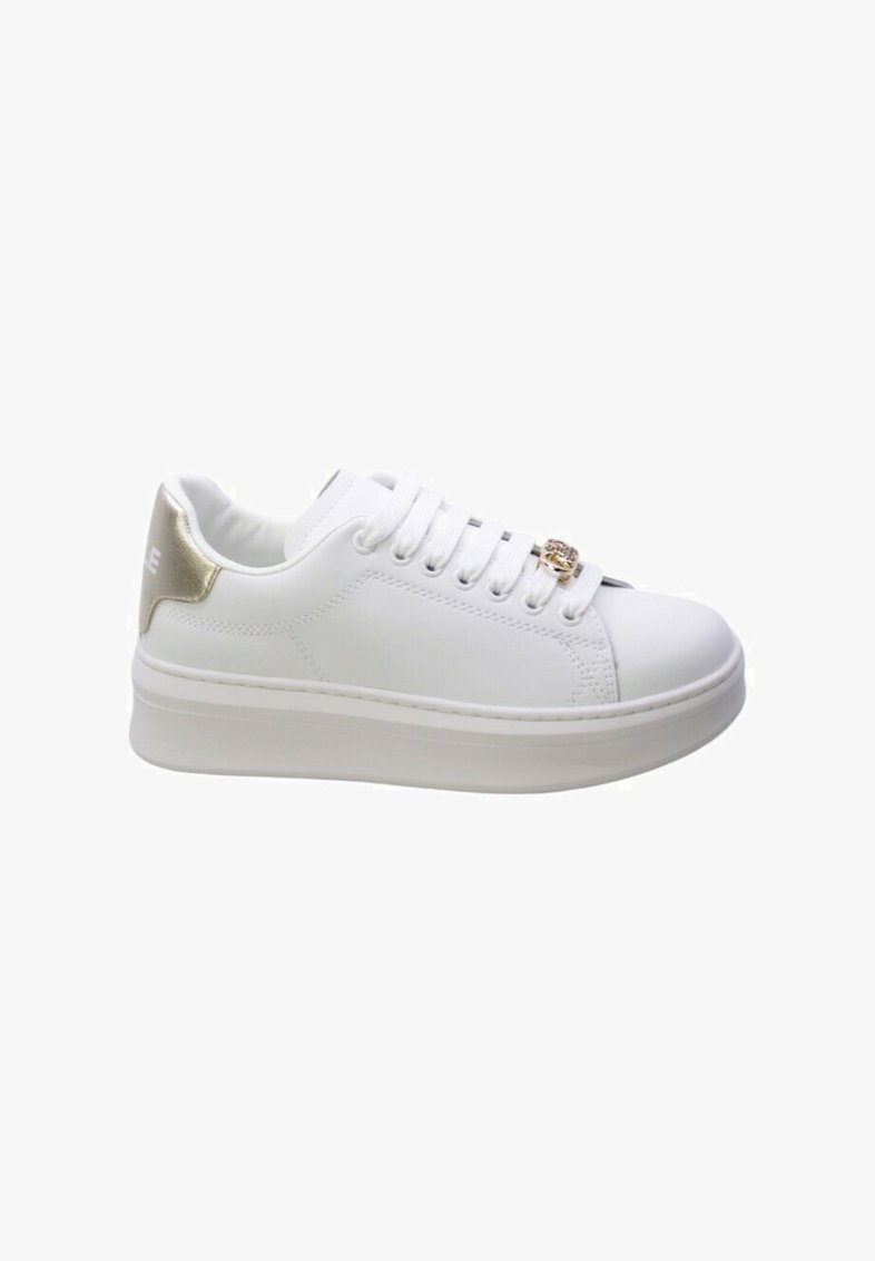 Sneaker bianco con una finitura liscia, suola piatta e un accento metallico dorato sul tallone. Presenta lacci intrecciati e occhielli decorativi.