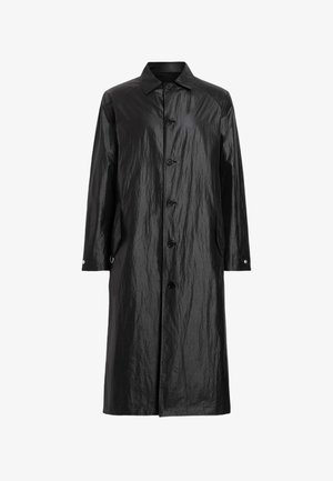 Svart, lång knäppkappa tillverkad av ett glänsande, skrynkligt material; har krage, två sidofickor och tryckknappsdetaljer på ärmarna.