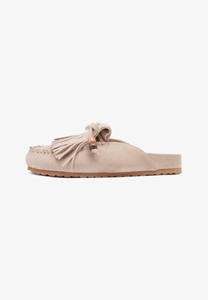 Mocassin beige en daim à enfiler avec franges et détail de perles en bois, semelle en caoutchouc, et bout arrondi cousu.