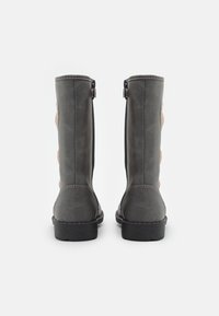 Bottes montantes en cuir synthétique gris avec une texture lisse, des zips latéraux et des accents décoratifs en matériau contrasté.