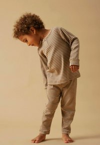 Striped brown and cream cotton pajama set with long sleeves, button detail, and pants, featuring a fitted design and soft texture.