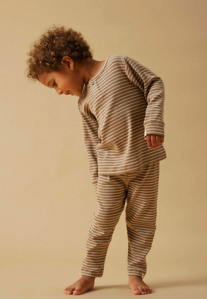 Striped brown and cream cotton pajama set with long sleeves, button detail, and pants, featuring a fitted design and soft texture.