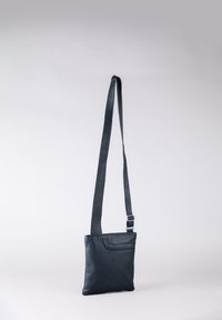 Black leather crossbody bag with an adjustable strap, smooth texture, flat shape, front slip pocket, and subtle logo detail at the center.