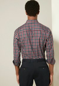 Mannen geruite blouse met een patroon in rood, marineblauw en grijs. Lange mouwen opgerold bij de manchetten. Ontworpen met een button-down kraag en een rechte achterkant.