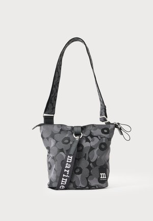 Sac à épaule noir et gris à motif floral avec sangle réglable et fermeture éclair, avec étiquette "marimekko" sur le devant.