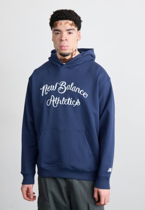 Navy blue hoodie with "New Balance Athletics" logo, kangaroo pocket, drawstring hood, and ribbed cuffs. Soft, cotton blend material.