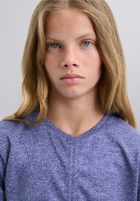 Blauwe heather v-hals shirt gemaakt van zachte, gestructureerde stof. Kenmerken zijn subtiele spikkels, korte mouwen en een ontspannen pasvorm.