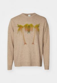 Pull en maille beige présentant un motif coloré de palmier au centre. Le tissu a une apparence texturée avec un col rond et des manches longues.
