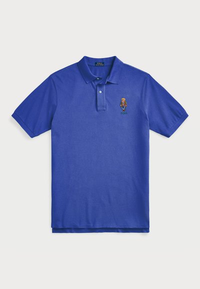 Blue polo shirt made of cotton, featuring a collared neckline, three-button placket, and an embroidered bear logo on the left chest.