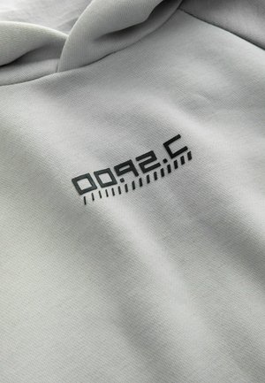 Hanorac gri cu o textură moale, având un logo grafic negru care citește "0092.C" și linii orizontale, poziționat pe partea din față.