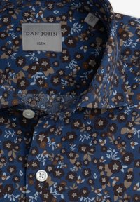 Slim fit -paita tummansinisestä kankaasta, jossa on ruskeita, kermaisia ja vaaleansinisiä kukkakuosia. Viimeistelty valkoisella napilla kauluksessa.