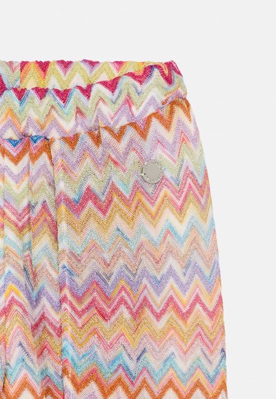 Tissu à motif zigzag multicolore avec une taille élastique froncée et un accent en métal de couleur argentée. Matière légère et texturée.