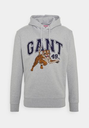 Hellgrauer Kapuzenpullover mit marineblauem Schriftzug „GANT 49“ und einer detaillierten orange-schwarzen Tiger-Grafik, die vorn darüber springt.