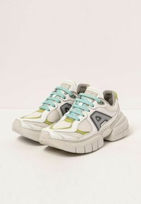 White sneakers with teal laces, grey accents, and lime green highlights. Features mesh panels and a chunky sole design.