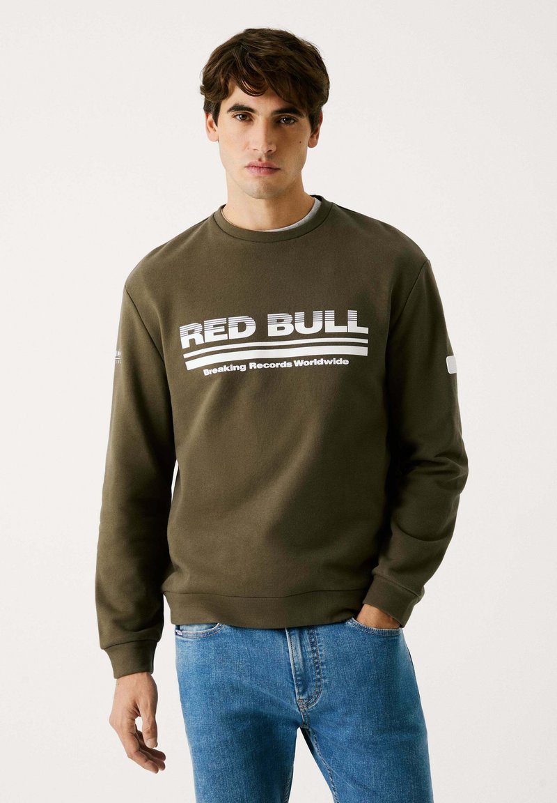 Olivgrön sweatshirt med "RED BULL" och "Breaking Records Worldwide" i vit tryck; har rund hals och ribbade ärmslut.
