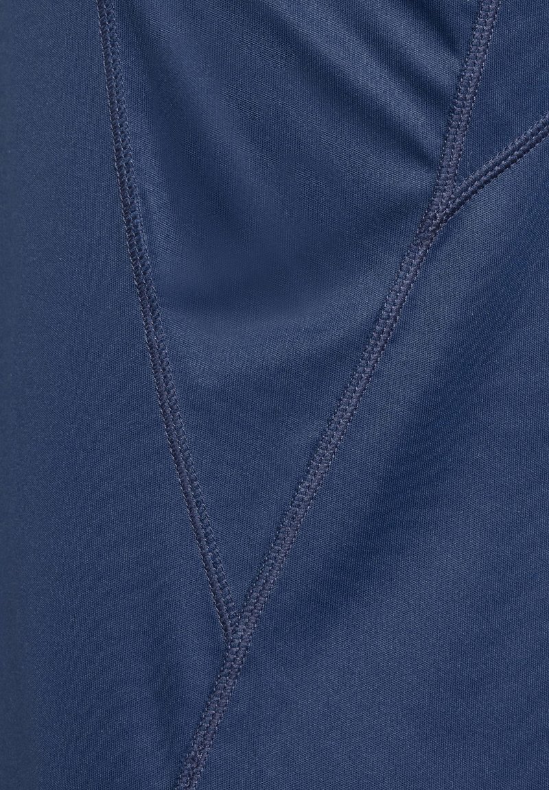 Marineblauer Stoff mit glatter Textur, sichtbaren Nähten und einem leichten Glanz. Das Design umfasst diagonale Nähte für zusätzliche Details.