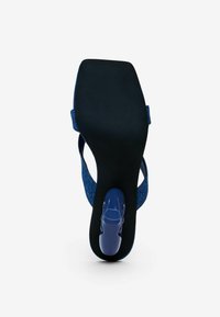 Blauer Sandale mit strukturiertem Obermaterial, verstellbarem Riemen und einer eleganten schwarzen Sohle mit runder Ferse.