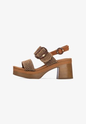 Sandalias de plataforma marrones tejidas con tiras anchas, hebilla ajustable en el tobillo y tacón grueso de madera. Superficie texturizada y detalles de costuras reforzadas.