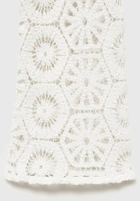 Weißer Häkelstoff mit hexagonalen und kreisförmigen Mustern, einer strukturierten Oberfläche und komplexen Details überall.