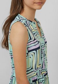 Ärmelloses Kleid in Pastellfarben mit geometrischem Muster, runder Halslinie und Rüschensaum, aus leichtem Stoff gefertigt.