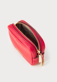 Red leather zippered pouch with a textured surface and gold-tone hardware, featuring a small chain accent and a spacious interior.