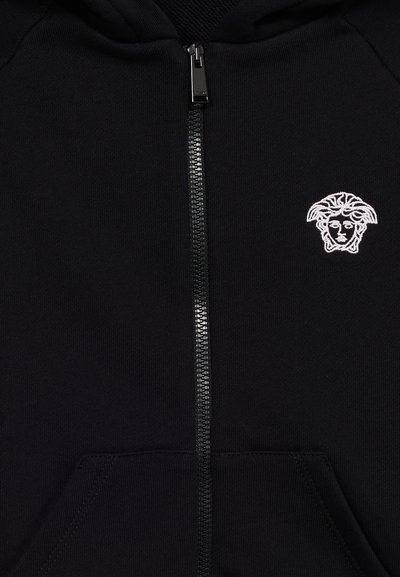 Μαύρο hoodie με φερμουάρ, εμπρόσθιες τσέπες και λευκό κεντητό λογότυπο κεφαλής Μέδουσας στην αριστερή πλευρά του στήθους.