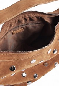 Borsa a mano in suede marrone con borchie in metallo argentato, chiusura con zip e rivestimento interno morbido. Presenta una tasca interna con zip e un'etichetta con il marchio.