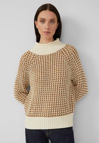 Strickpullover mit hohem, geripptem Kragen, cremefarbener Basisfarbe mit braunem Strukturmuster und langen Ärmeln mit gerippten Bündchen und Saum.